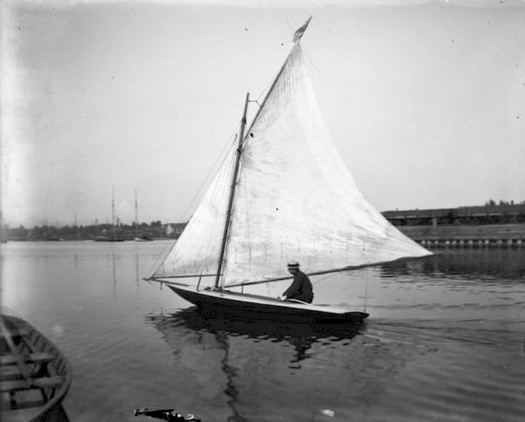 Pennyfeather sitting in a small sailboat in Milwaukee Harbor, 1898