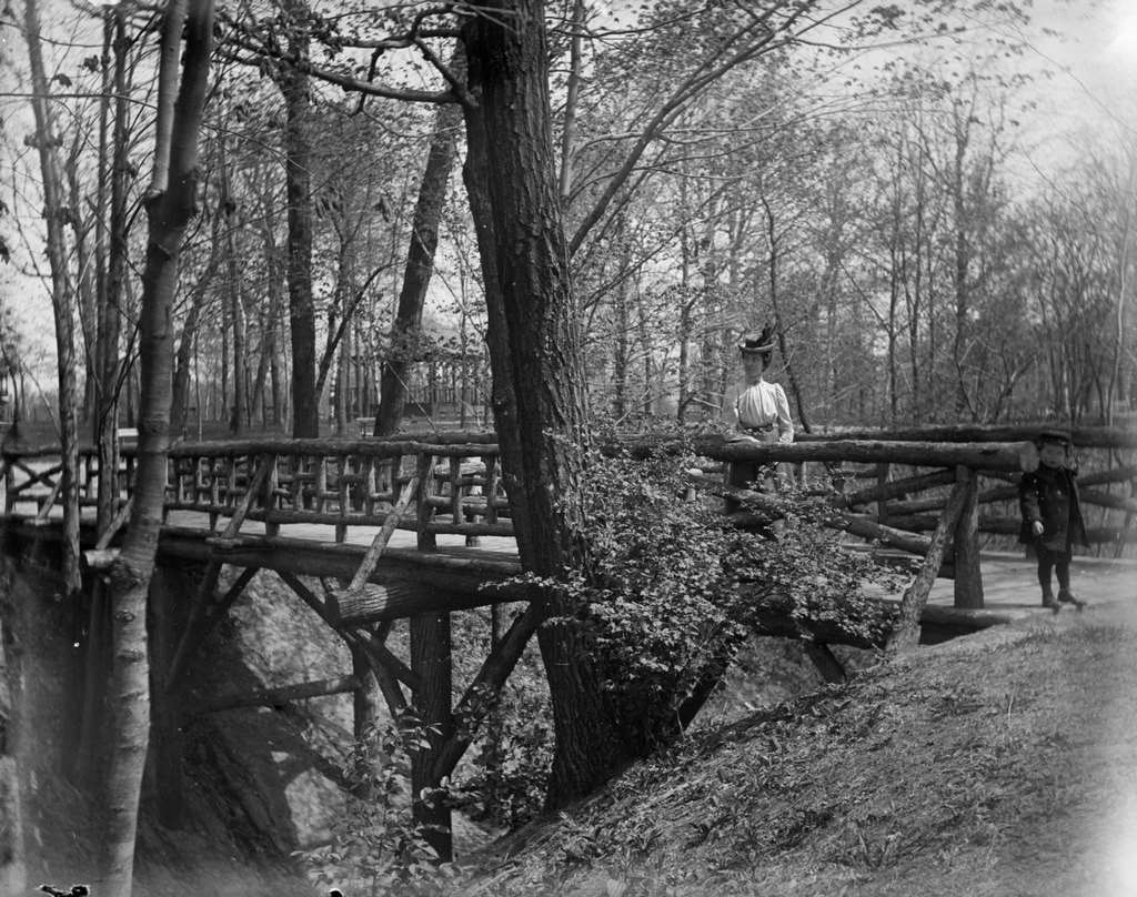 Aunt Helen and Syl stand on a rustic wooden bridge in Gully Lake Park, Milwaukee, Wisconsin, May 14, 1899.