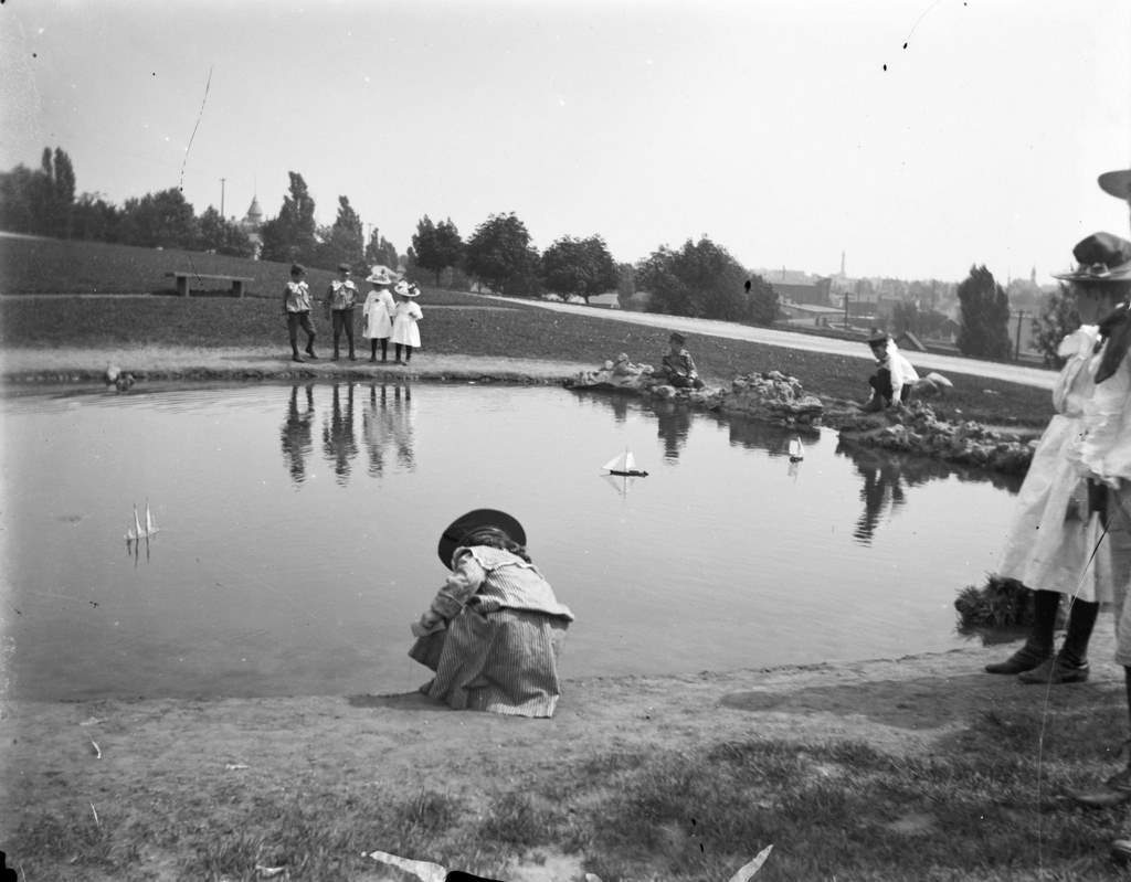Syl playing with toy boats at a small pond at Reservoir Park, Milwaukee, Wisconsin, August 28, 1898.