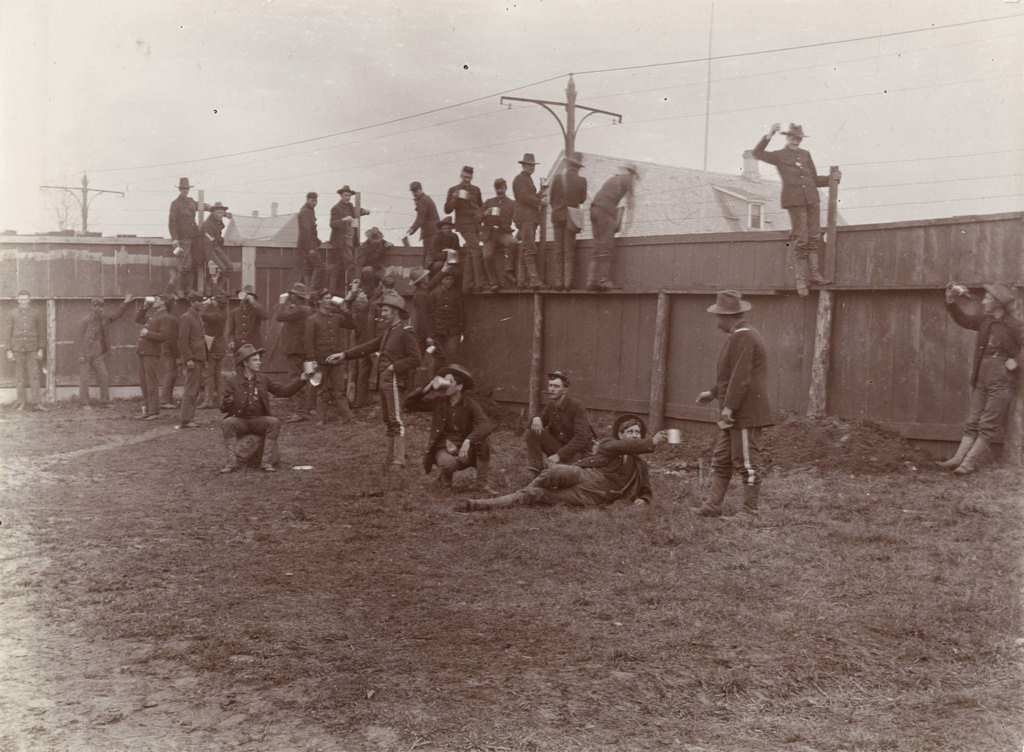 A group of soldiers from Company A, 3rd Regiment, take a break to drink inside the walls of Camp Harvey, Milwaukee, Wisconsin, 1898.