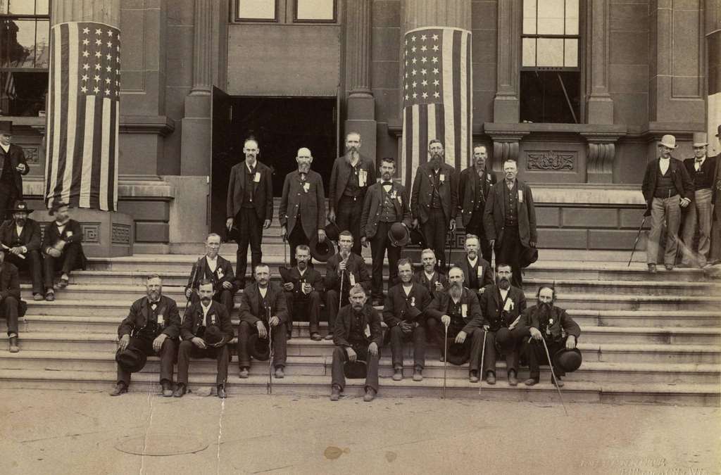 Group portrait outdoors of the Veterans of Company I, 29th Wisconsin Volunteer Infantry at a Grand Army of the Republic reunion, Milwaukee, Wisconsin, 1887.