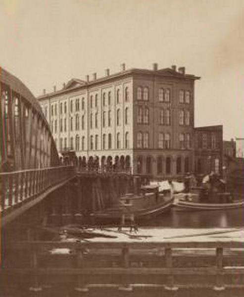 Axtell House building, with a storefront next to it advertising "Clothing Hats Caps Sailors Outfits"., 1869