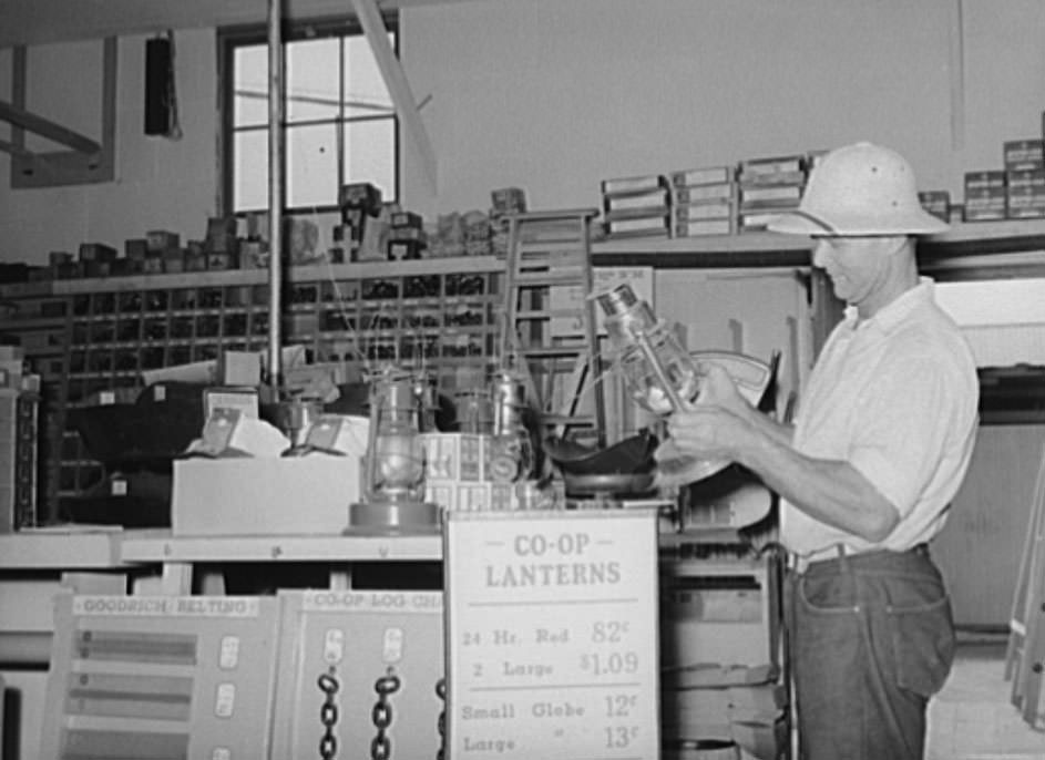 Member of the United Producers and Consumers Cooperative looking at a lantern in the store of the organization, Phoenix, Arizona, 1940