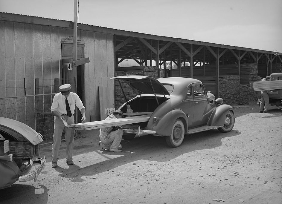 Member of the United Producers and Consumers Cooperative loading lumber into his car, Phoenix, Arizona, 1940