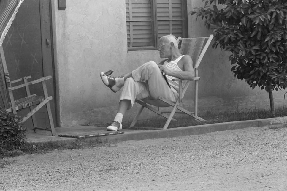 Sun bather swatting fly, tourist court at Phoenix, Arizona, 1940