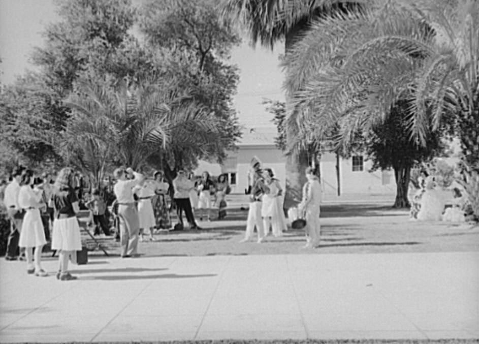 High school students watching fellow classmates being photographed in their graduation play costumes, 1940