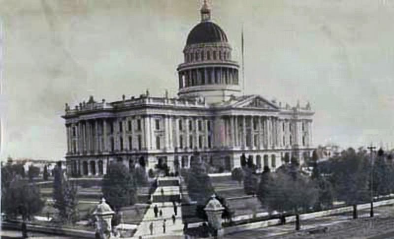 View of the state capitol from 10th and L Streets; shows people walking on the sidewalk from the corner towards the capitol building, 1882