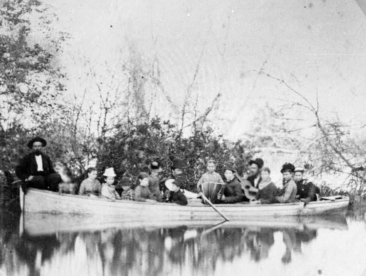 View of a group of people in a boat on the Sacremento River, 1885