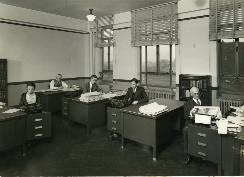 Five St. Louis Globe-Democrat employees working at their desks, 1930