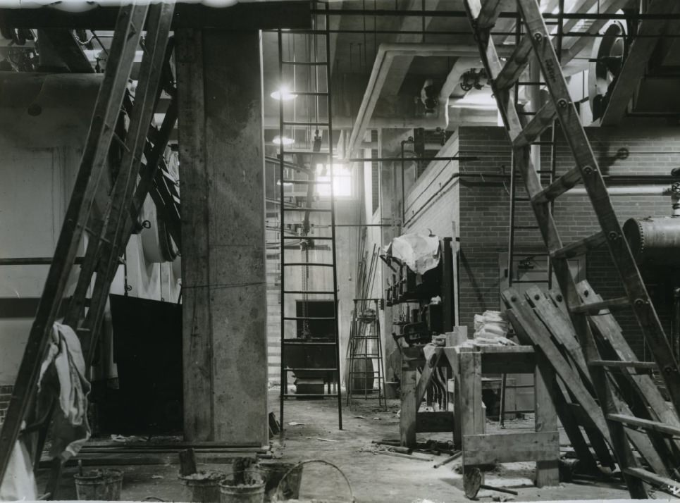 Automatic stokers are going to feed coal into three big boilers to provide low-pressure steam heat for the drill-roomacreage, 1938