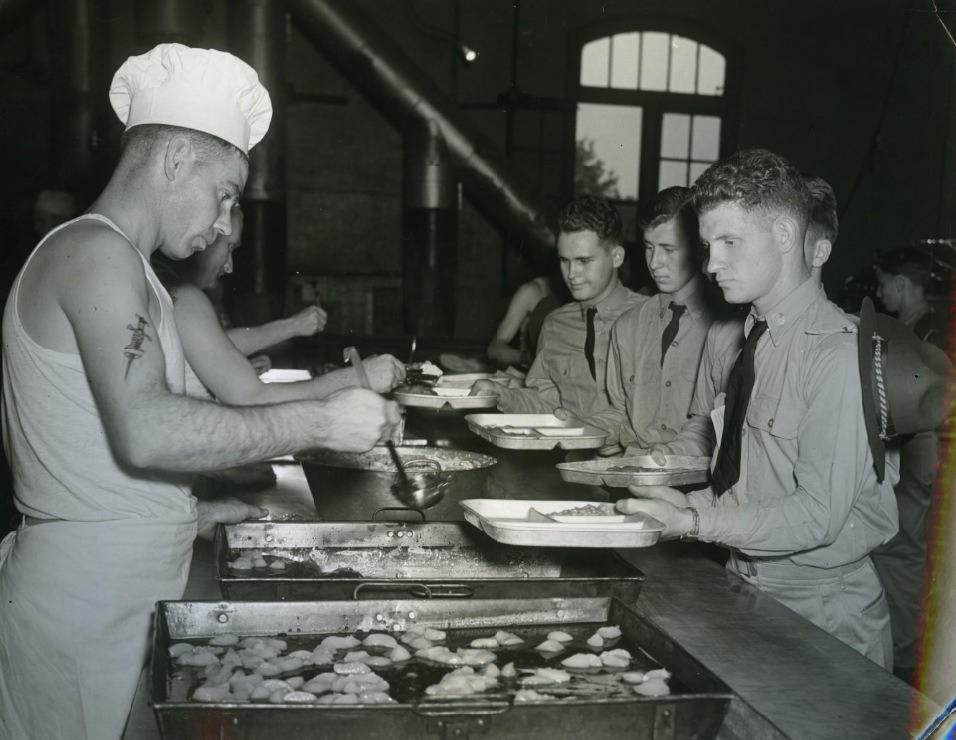 The trainees took time out at noon for a hearty meal of baked beans, tomatoes, salad, bread and apple butter, served cafeteria style and with a minimum loss of time, 1939