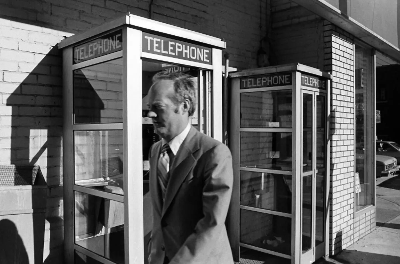 Man walking by phone booths in 1980.