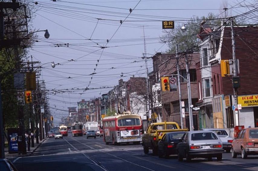Two types of streetcar and a trolley bus on Queen just west of Shaw, July 13, 1983.