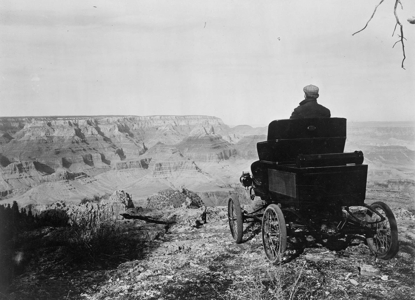A man sits in a Toledo Steam Carriage on the rim of the Grand Canyon, 1902