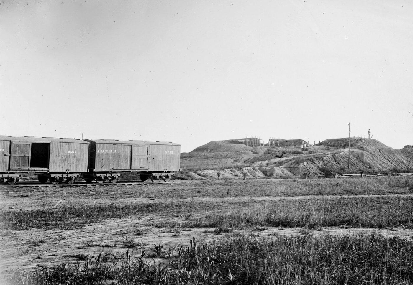 US military railroad boxcars travel along the Orange & Alexandria railroad line, Confederate fortifications are visible on the right, 1862.