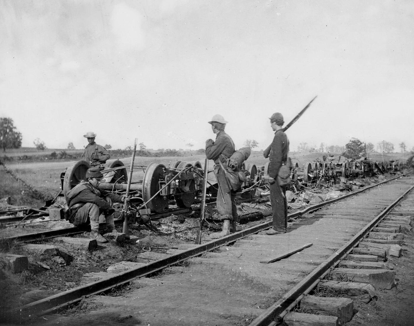 Soldiers stand beside damaged rolling stock of the Orange & Alexandria Railroad, 1862