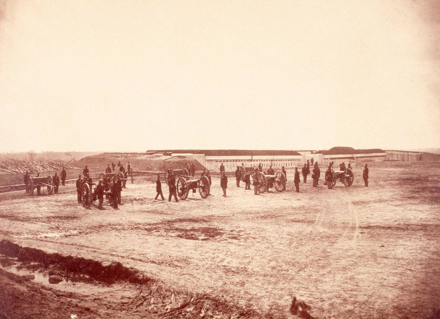 Abatis surrounds the perimeter of Fort Lyon, Virginia, near where Union gunners pose with their cannons, 1860s