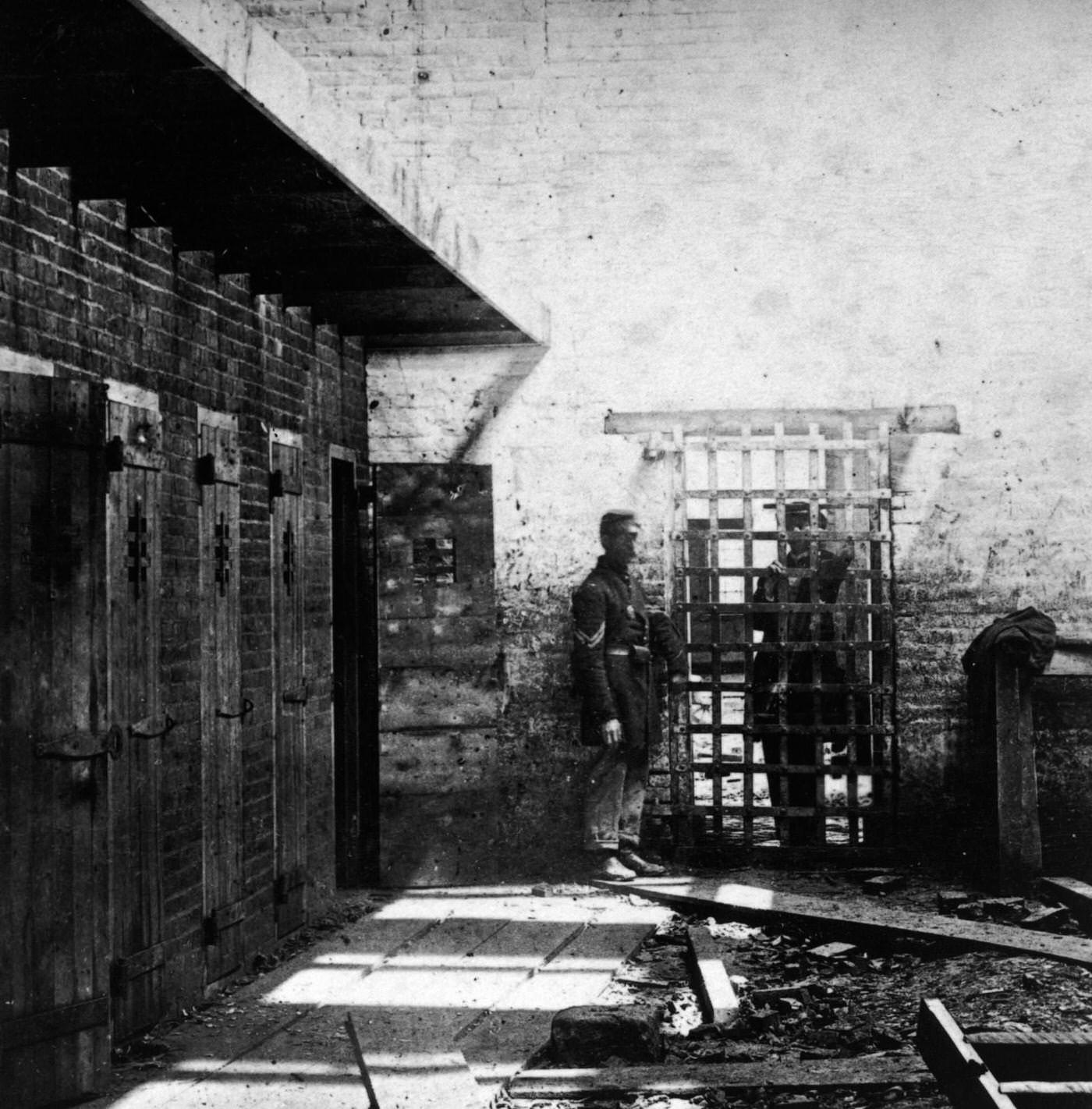 Two soldiers stand beside slave pen cells in Alexandria, Virginia, 1861.