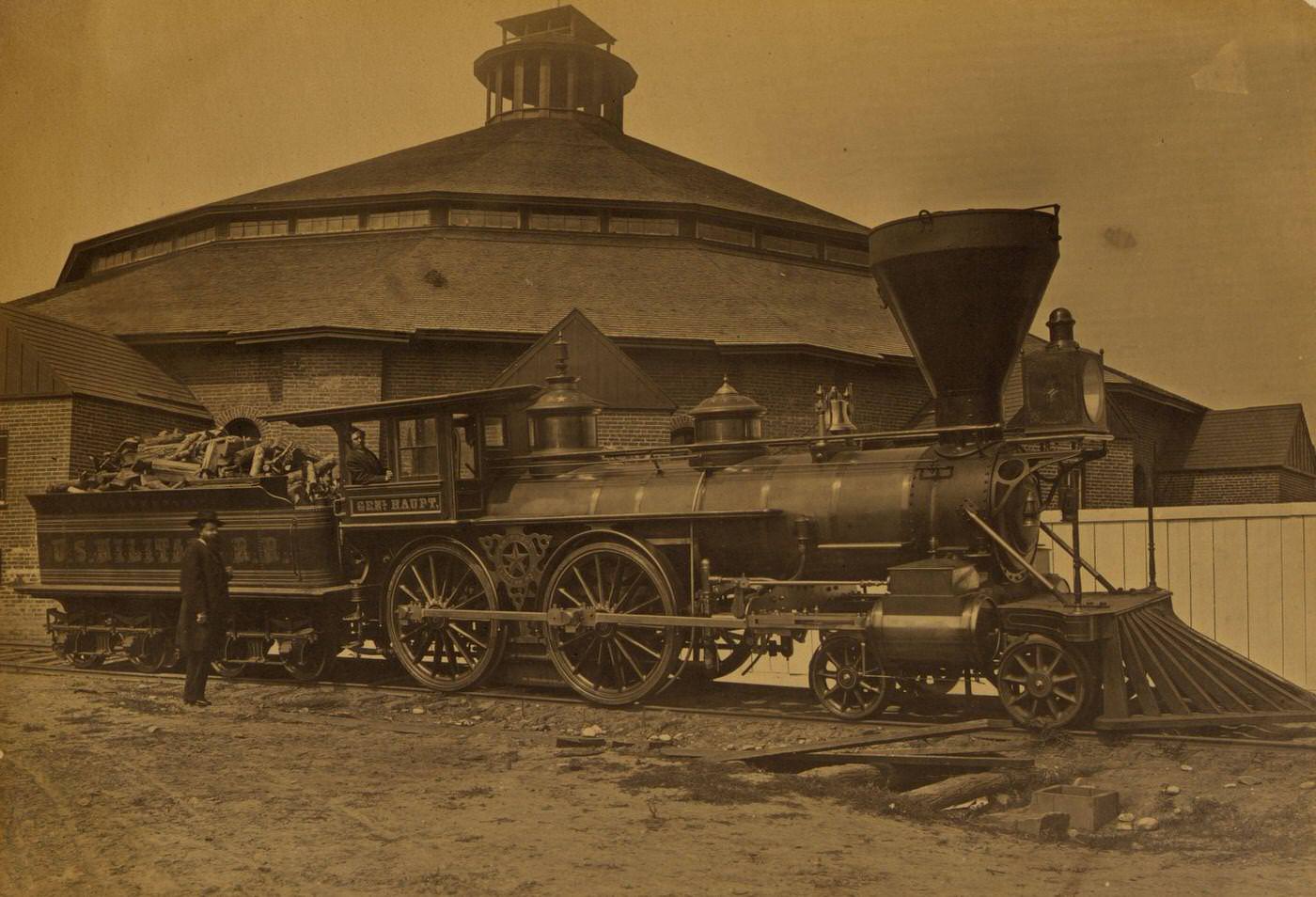 Wood burning locomotive "Gen. Haupt" named for Herman Haupt, chief of Construction and Transportation, in front of the roundhouse at the Alexandria station, 1863