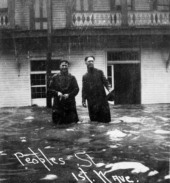 Two men wade onto Peoples Street as water begins to push into the streets as the 1919 hurricane approached.