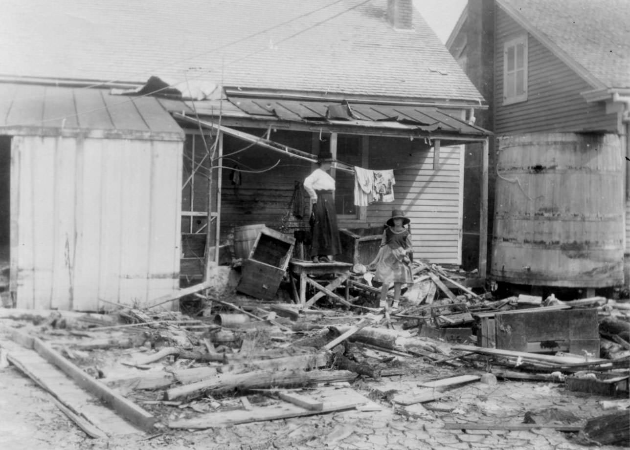 A woman standing on her back porch looking over the debris and wreckage left by the hurricane of 1919 in Corpus Christi.