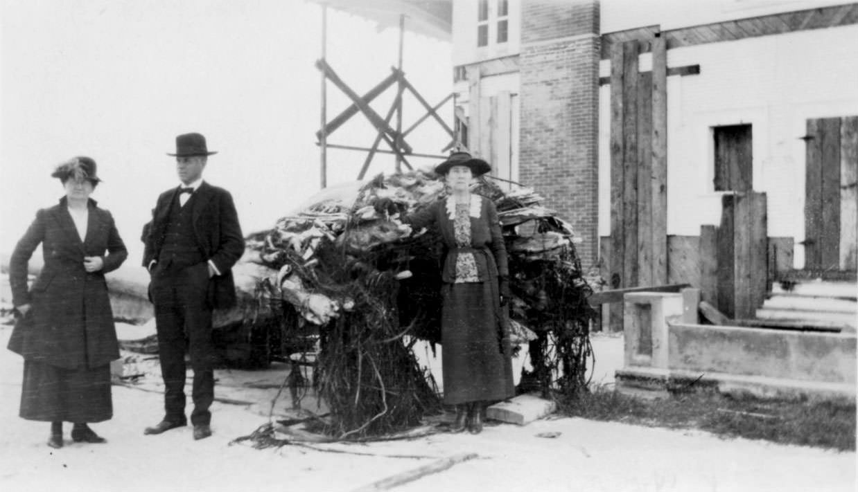 Two women and a man standing by the ruins of a house after the 1919 hurricane in Corpus Christi.
