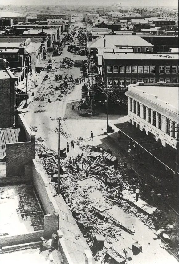 This photo was taken from the top of the Nueces Hotel looking south down Chaparral Street as men cleared debris following the 1919 hurricane.