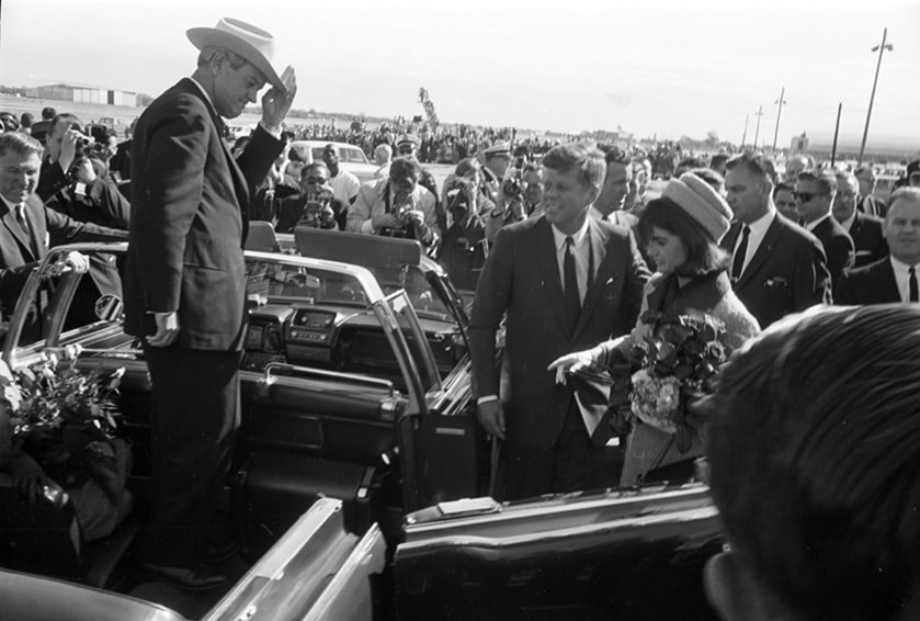 President John F. Kennedy and wife Jackie Kennedy as they enter a convertible limousine at Love Field, Dallas, Texas, 1963