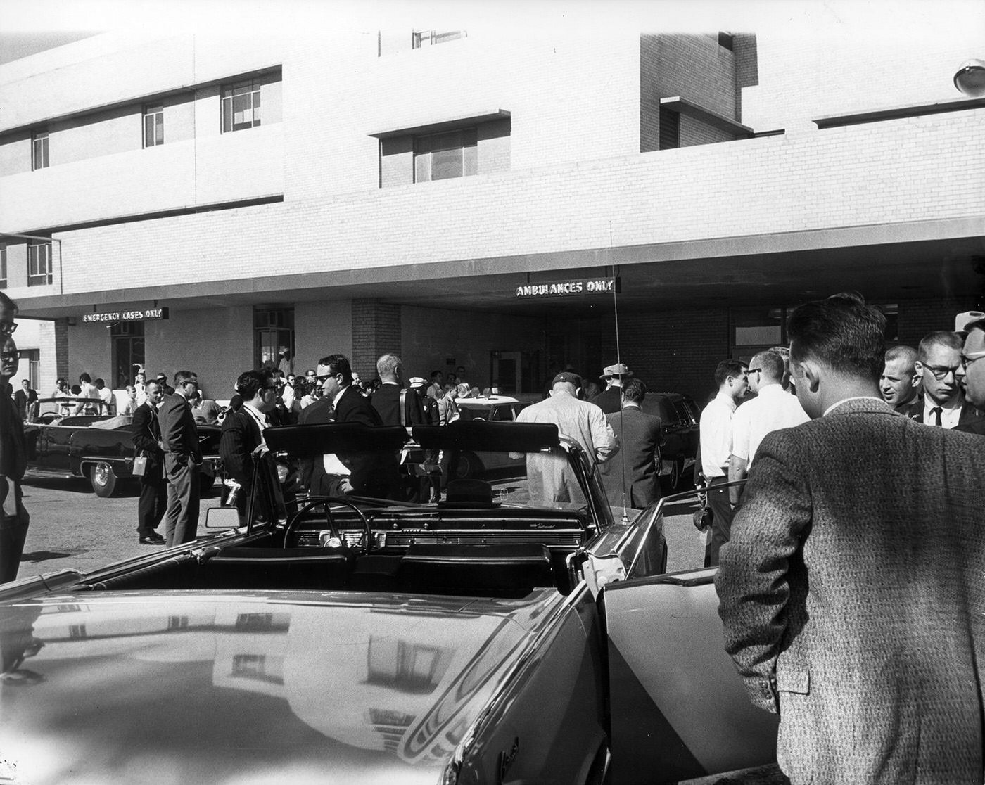 Crowd awaiting news outside Emergency Room entrance of Parkland Hospital following assassination of President John F. Kennedy, 1963