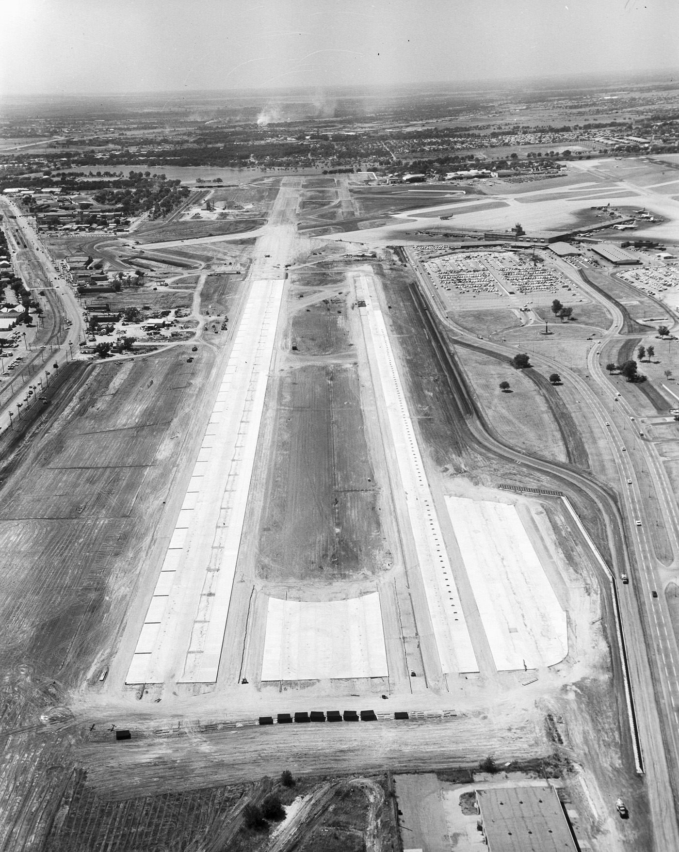 Runway at Love Field, Dallas. There are airplanes parked, 1960