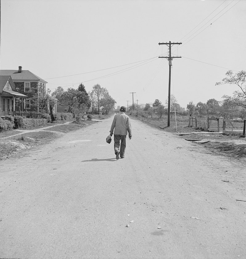Shipyard worker leaving his rural home for the shipyards with his lunch box, 1942