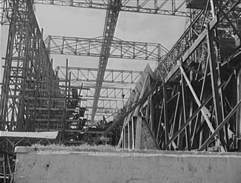 Thousands of tons of lumber and steel are used in the construction of these ways, where American mechanical genius is employed in the production of ships for our new two-ocean Navy, 1941