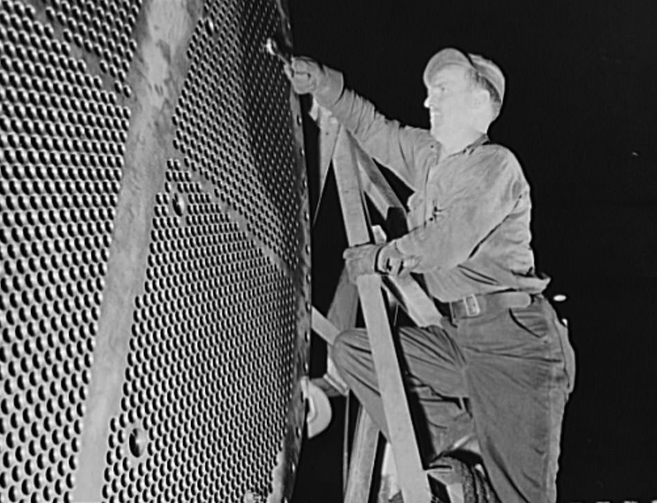This worker is touching up one of the huge condensers for a U.S. Navy destroyer under construction, 1941