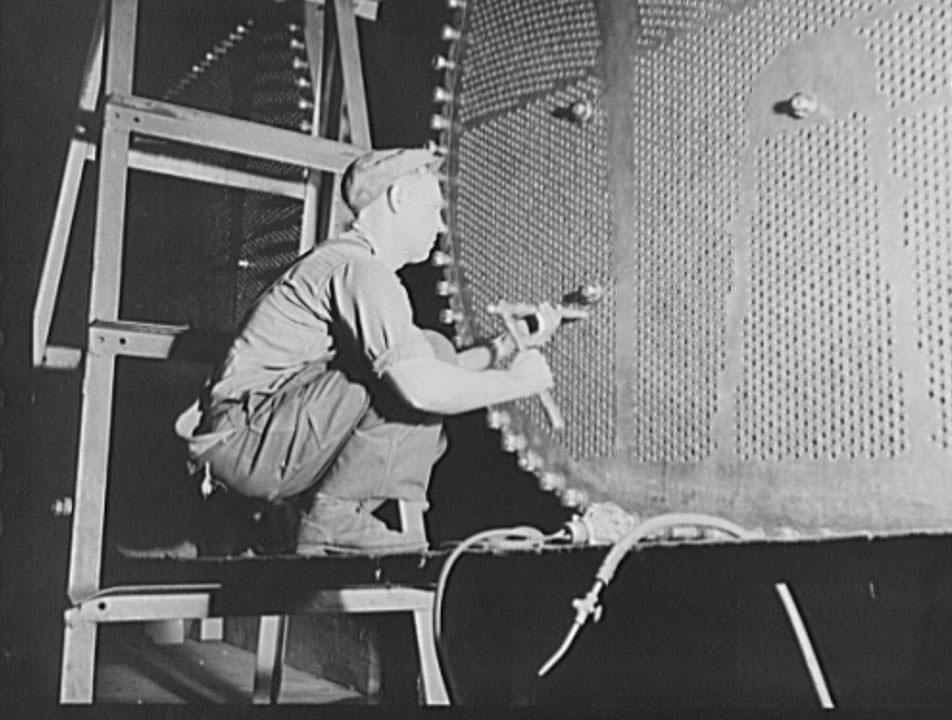 This worker is touching up one of the huge condensers for a U.S. Navy destroyer under construction, 1941