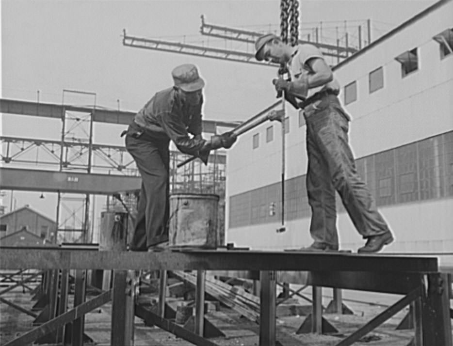 These workers are red-leading a pipe, to prevent corrosion, 1941