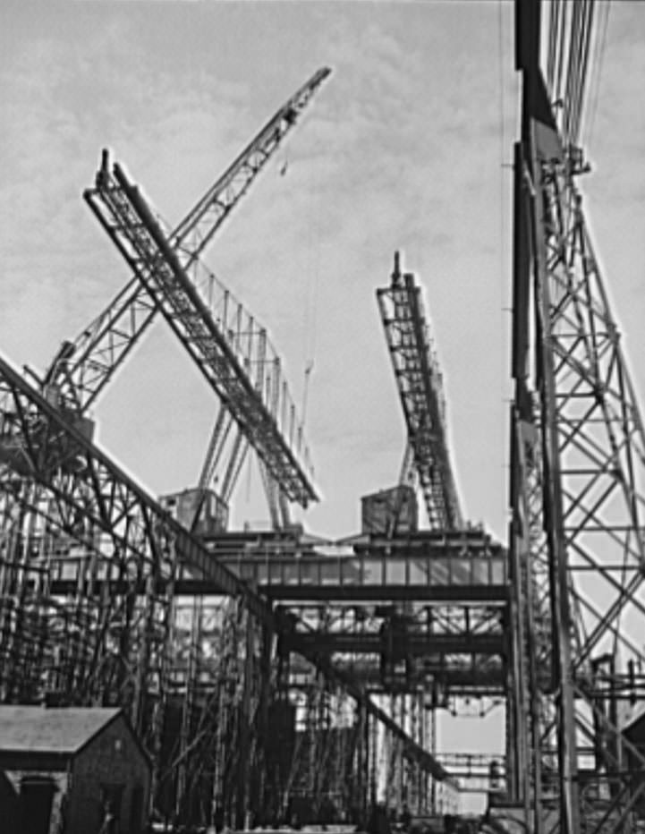 Huge overhead cranes are used for the placing of heavy parts in the naval ships under construction at these ways, 1941