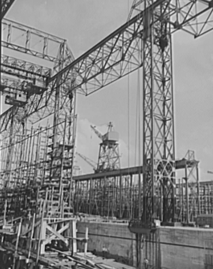 Thousands of tons of lumber and steel are used in the construction of these ways, where American mechanical genius is employed in the production of ships for our new two-ocean navy, 1941