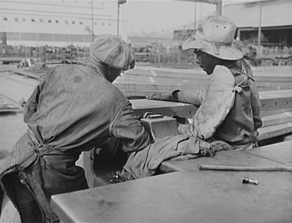 These two skillful workers are punching rivet holes in the frame of a ship on the ways, 1941