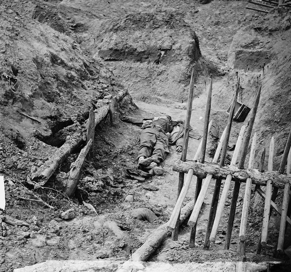 Dead Confederate soldier, in trench beyond a section of chevaux-de-frise, 1865