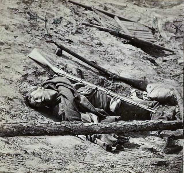 Stereograph showing a dead Confederate soldier with gun in the trenches of Fort Mahone, near Petersburg, Virginia on April 2, 1865.