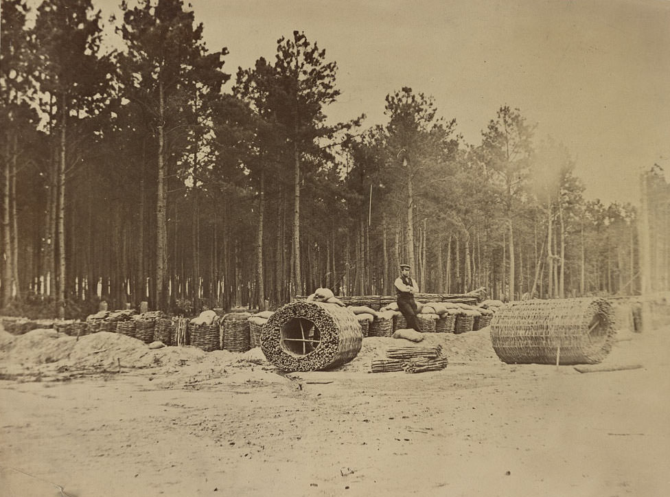 Man seated on gabions in engineer camp in front of Petersburg, 1864