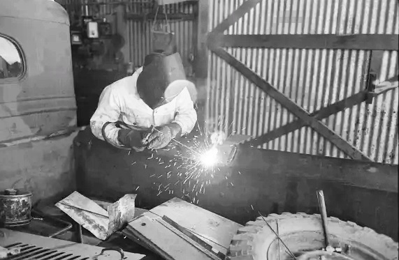 A worker repairs a farmer's truck with an electric welder in Phoenix during May 1940.