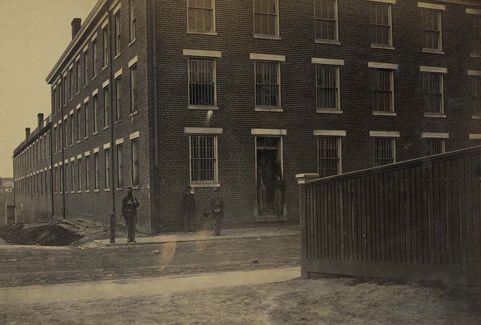 A Union guard standing next to Castle Thunder, a Confederate military prison in Richmond, Virginia, 1865