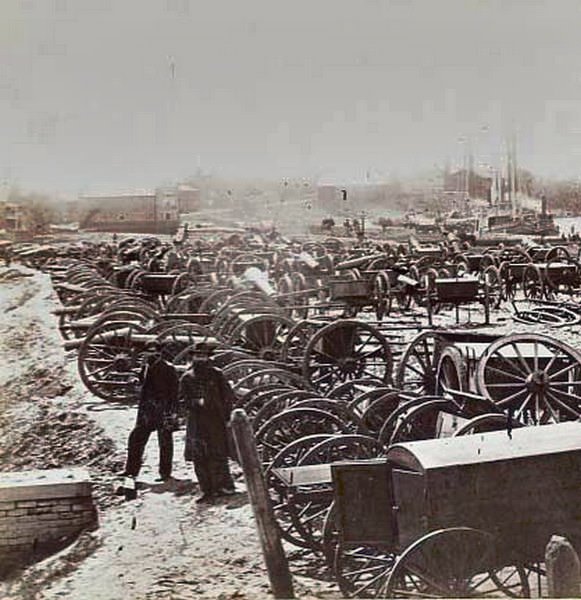 Two Union soldiers standing amid the cannons and caissons captured by the Union near Rocketts in Richmond, Virginia, 1865