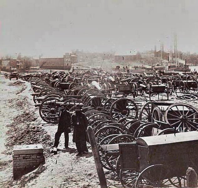 Two soldiers standing amid the cannons and caissons captured by the Union near Rocketts in Richmond, Virginia, 1865