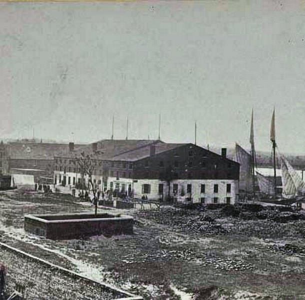 Exterior view of the prison with people milling about in the prison yard, Richmond, 1865