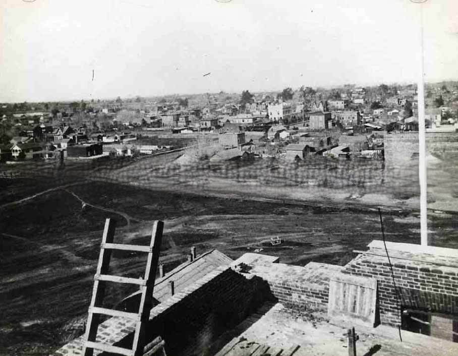 Cityscape of Sacramento taken from the state capitol building under construction. Typed on the back of the image "Corner of 10th & N street in the year 1868.