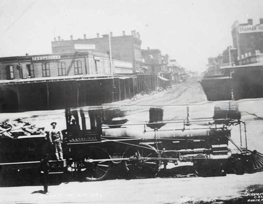 Central Pacific engine, A.A. Sargent, at J and Front Streets, 1865