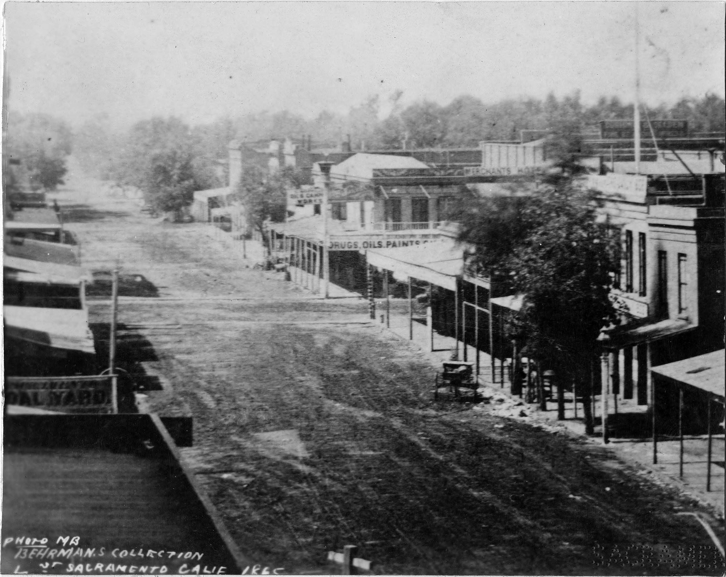 L Street circa 1865 is depicted with unpaved streets and wooden sidewalks, 1865