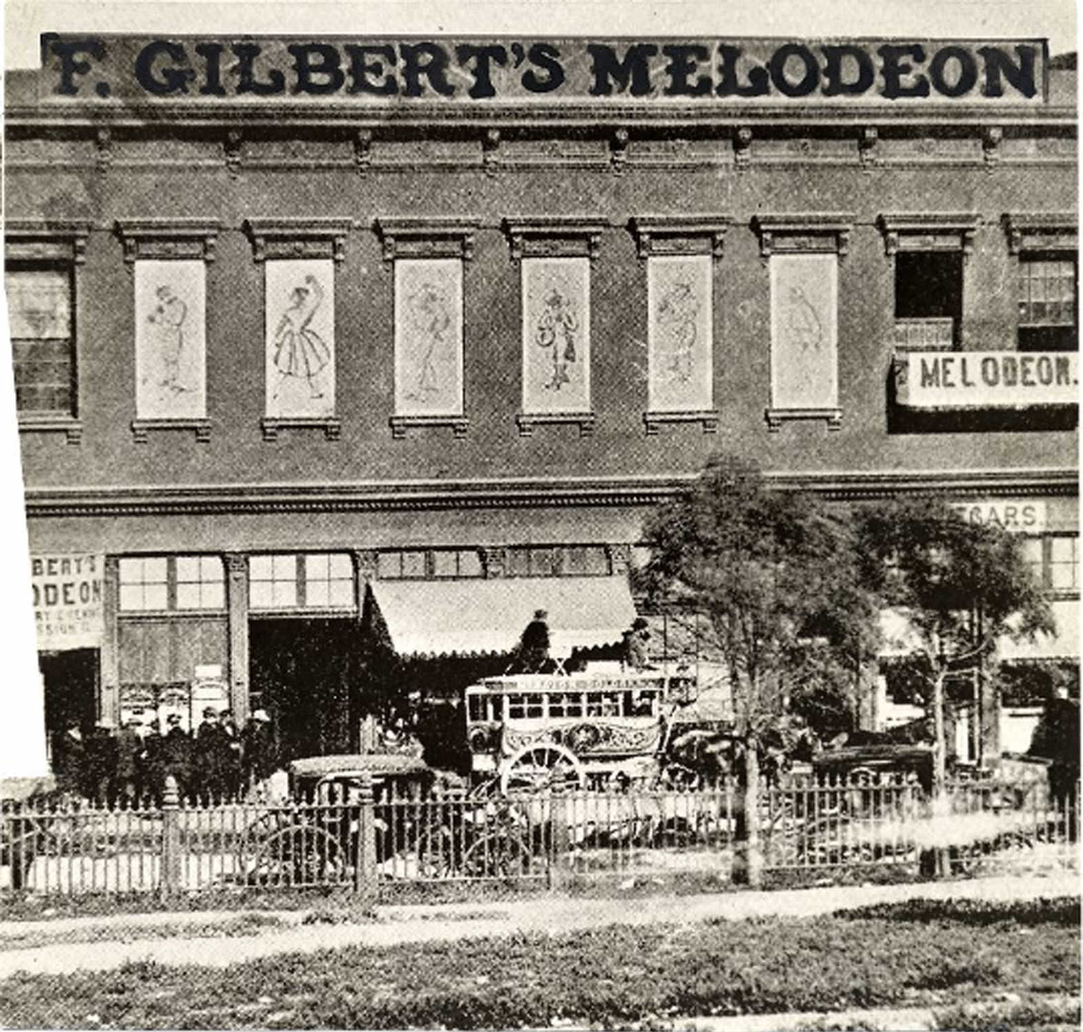 A stagecoach and several unidentified people outside of the F. Gilbert's Melodeon theater located at Clay and Kearny Streets, 1854
